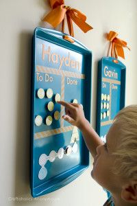 a young boy pointing to a board with magnets on it