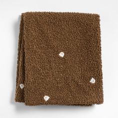 a brown blanket with small white hearts on the front and back, folded in two rows