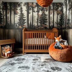 a baby's room with an animal themed wallpaper and wooden cribs