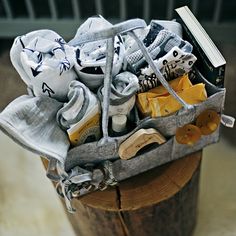 a bag filled with baby shoes sitting on top of a wooden stump