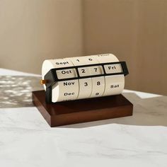 a clock that is sitting on top of a wooden stand in the middle of a table