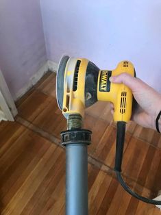 a person is holding a drill in their hand and drilling the floor with a power drill