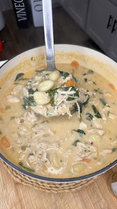 a bowl filled with soup sitting on top of a wooden table next to a spoon