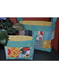 two baskets sitting on top of a table next to a potted plant