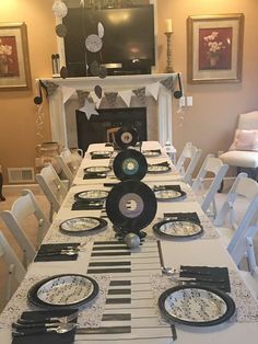 a long table set with black and white plates, silverware, and place settings