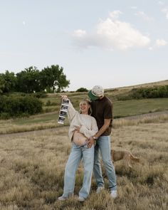 a man and woman standing in a field with a skateboard on their stomachs