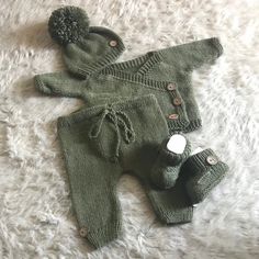 a knitted baby outfit and booties laying on a white carpet