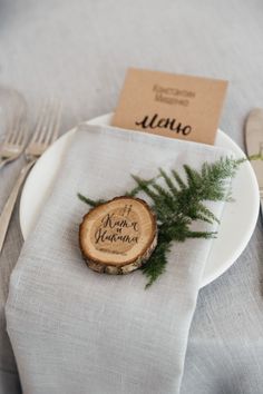 a place setting with silverware, napkins and wooden slices on the table for guests to eat