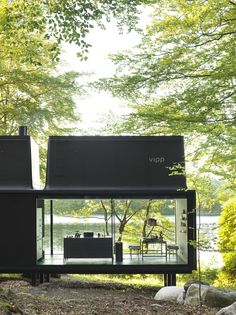 the house is surrounded by trees and water, with its windows open to let in light