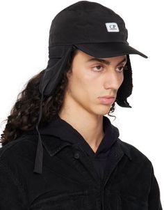 Garment-dyed Chrome-R® pre-consumer recycled nylon taffeta cap in black. · Water-resistant and quick-drying · Logo patch at face · Curved brim · Ear flaps · Adjustable chin strap · Bungee-style drawstring at back face · Twill browband · Fleece lining Supplier color: Black Black Waterproof Hats With Short Brim, Waterproof Black Hats With Short Brim, Black Waterproof Hat With Short Brim, Black Windproof Sporty Hats, Black Sporty Windproof Hats, Sporty Windproof Black Hat, Sporty Black Windproof Hats, Black Waterproof Visor Hat, Black Nylon Bucket Hat