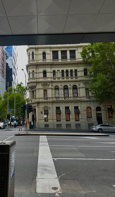 an old building is on the corner of a street in front of some tall buildings