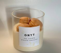 a candle with some cookies in it on a white table next to a glass container