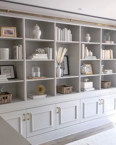 a living room filled with lots of white bookshelves