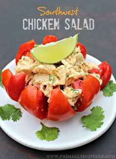 chicken salad on a plate with cilantro and lime wedged in the middle