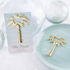 a palm tree brooch sitting on top of a blue plate next to a bottle