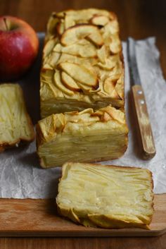 sliced apple pie sitting on top of a cutting board next to an apple and knife