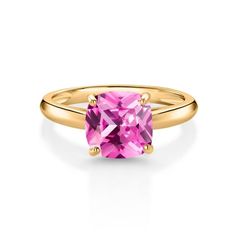 a gold ring with a pink topazte stone in the center, on a white background