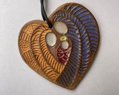 a heart shaped ceramic ornament hanging on a cord