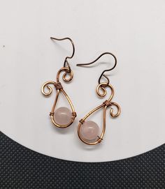 These earrings were made from copper wire and feature a genuine rose quartz stone bead in the center. The earring hooks are nickel free and copper colored to match. Rose Gold Wire Wrapped Copper Wire Earrings, Rose Gold Wire Wrapped Earrings In Copper, Rose Gold Wire Wrapped Earrings, Nickel Free Rose Gold Copper Wire Earrings, Nickel-free Rose Gold Copper Wire Earrings, Elegant Rose Gold Earrings With Copper Wire, Adjustable Wire Wrapped Rose Gold Earrings, Adjustable Rose Gold Wire Wrapped Earrings, Pink Copper Drop Earrings