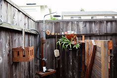 an outdoor shower with wooden fence and potted plant