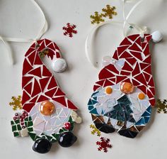 two christmas ornaments made out of mosaic tiles and glass beads on a white table with snowflakes