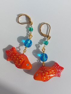 Handmade goldfish earrings. Cute, sparkly and unique. Fish is made from lightweight polymer clay and hand-painted. Beads are made from czech glass. Earrings are one of a kind :) Length from the hook: 6.4 cm / 2.52 inches. Earrings will arrive packed in cute decorative paper, so you will be able to gift them without the need for additional gift wrapping. Disinfect the hook before wearing. CARE INSTRUCTIONS:  Do not keep your earrings in direct sunlight as it may affect the metal color. Be gentle with your earrings; avoid playing with them or pulling on them. Do not bathe while wearing your earrings; keep them away from water. Keep earrings in a dry, shaded place. Keep each pair of earrings separate from each other because different types of metals can react, potentially causing changes in t Goldfish Earrings, Unique Fish, Painted Beads, Fish Earrings, Beach Earrings, Le Crochet, Earrings Polymer Clay, Handmade Jewelry Gift, Decorative Paper