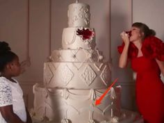 a woman in a red dress standing next to a white wedding cake with an orange arrow pointing at it