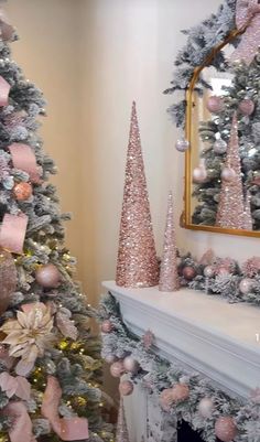 a decorated christmas tree in front of a fireplace with pink and silver decorations on it