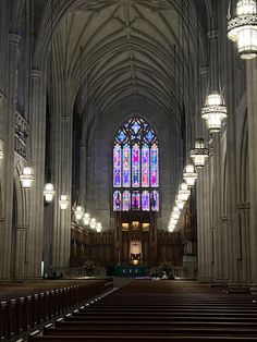 the interior of a large cathedral with stained glass windows