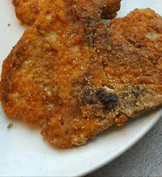 two pieces of fried chicken on a white plate