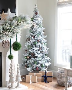 a white christmas tree with presents under it