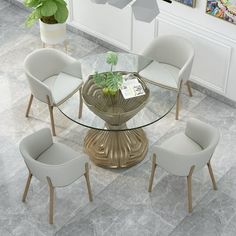 a glass dining table with four chairs around it and a potted plant on top