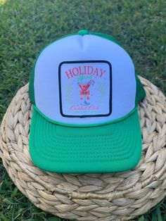 a green and white trucker hat sitting on top of a woven wicker basket