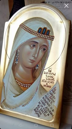 an icon of the virgin mary magdalene in gold with pearls on it's head