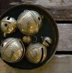 four silver objects in a metal bowl on a wooden table