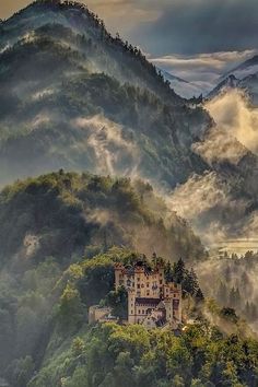 a castle on top of a mountain surrounded by fog