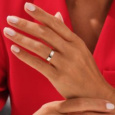 a woman's hand with a ring on her left wrist, wearing a red shirt