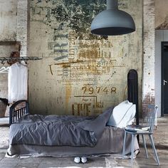 a bedroom with an old wall and bed in the foreground, next to a chair