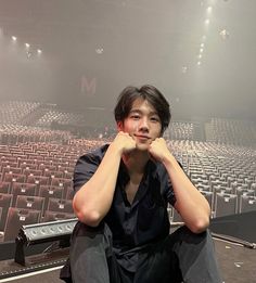 a man sitting on the floor in front of an empty auditorium