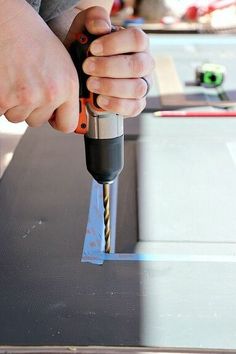 a person using a drill to cut metal