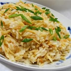 a white plate topped with rice and green onions