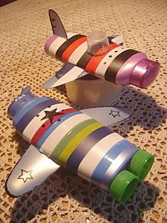 three toy airplanes sitting on top of a table next to each other and one plane is multicolored