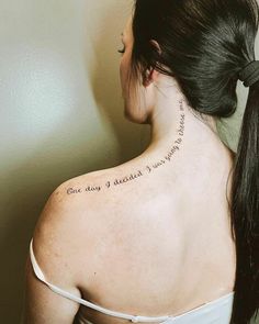 a woman with a tattoo on her back neck and the words one day at a time written in cursive writing