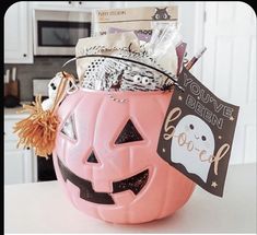 a pink pumpkin shaped container filled with halloween items