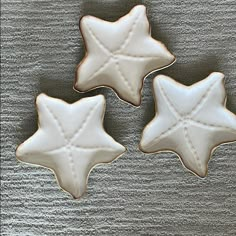 three decorated cookies sitting on top of a table