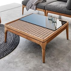 a coffee table sitting on top of a rug next to a couch