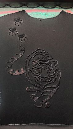 a close up of a black piece of cloth with a drawing of a tiger on it