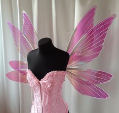 a pink corset with wings on top of a mannequin headdress