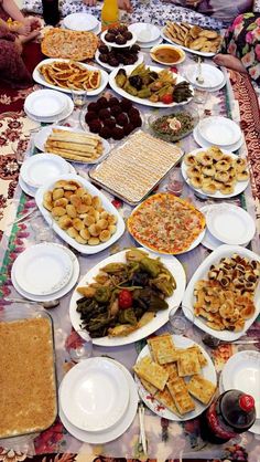 a table filled with lots of food on top of white plates and silver wares