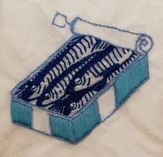 an embroidered box with three fish in it